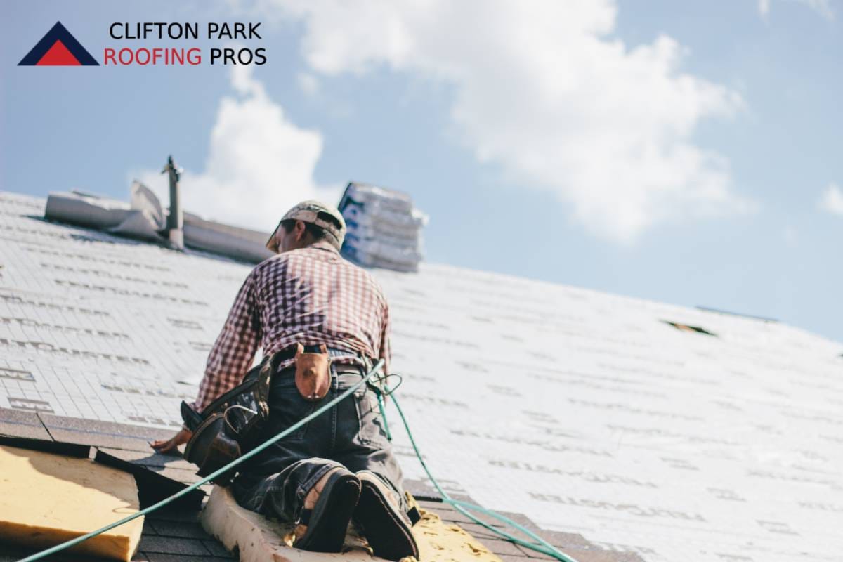 Roofer inspecting steep-pitch roof in upstate New York